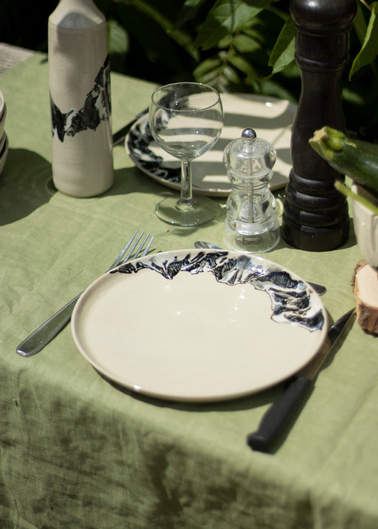 Photo d'une assiette en grès blanc brillant décorée de montagnes en noir et blanc