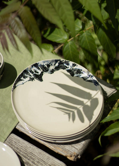 Photo d'une assiette en grès blanc brillant décorée de montagnes en noir et blanc